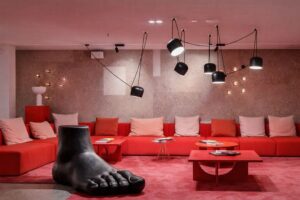Färgglad lounge på ett kontorshotell med röd inredning och ovanlig konst.